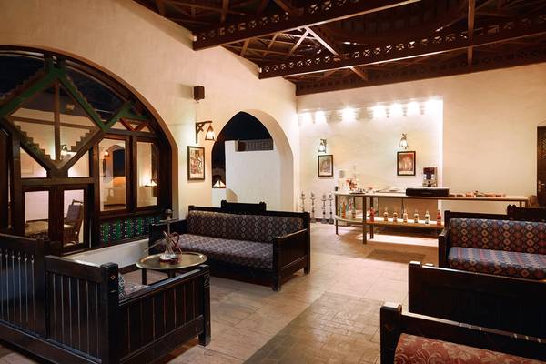 Loungebereich im Arabella Azur Beach Resort mit gemusterten Sofas und einer Theke.