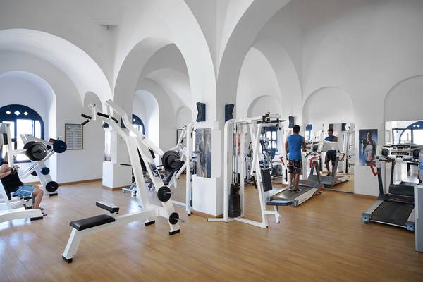 Fitnesscenter im Arabella Azur Beach Resort mit verschiedenen Trainingsgeräten und Personen, die trainieren.