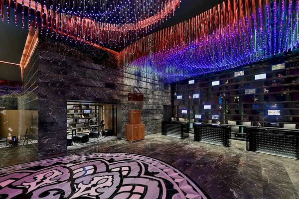 Lobby des W Muscat Hotels mit leuchtenden Lampen und Marmorboden.