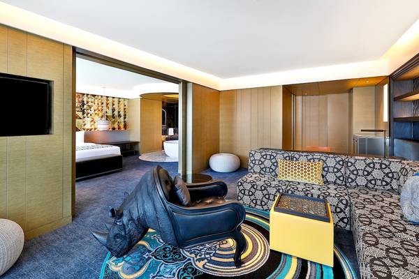 Innenansicht der Suite im W Muscat Hotel mit afrikanischem Rhino-Dekor, modernen Möbeln und offenem Badezimmerbereich.