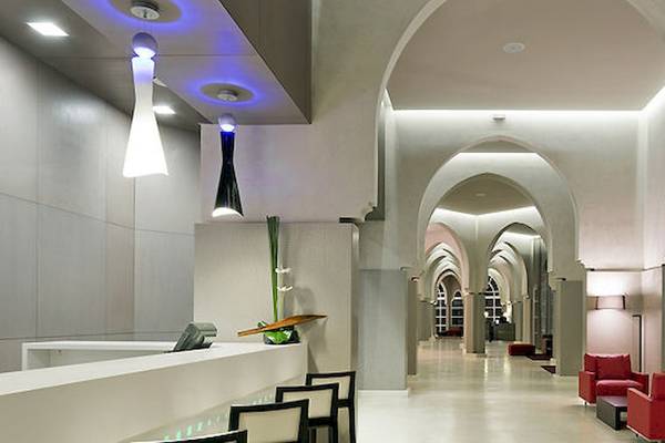 Empfangsbereich des Barcelo Palmeraie Hotels mit roten Sesseln und moderner Architektur.