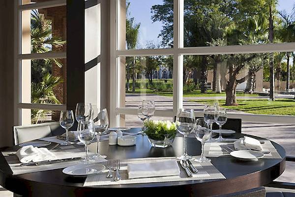 Speisesaal im Barcelo Palmeraie Hotel mit Tisch, Gläsern und Blick auf den Garten