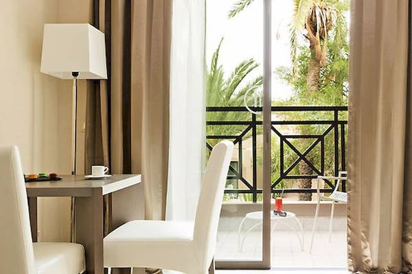 Zimmer im Barcelo Palmeraie Hotel mit Blick auf einen Balkon und Außenbereich.