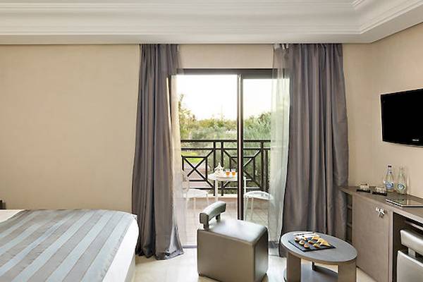 Hotelzimmer im Barcelo Palmeraie Hotel mit Balkon und Ausblick auf den Garten.