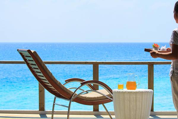 Frau auf dem Balkon mit einem Getränk im Velassaru Maldives.