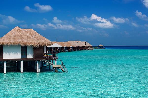 Außenansicht des Velassaru Maldives mit Wasserbungalows am Strand