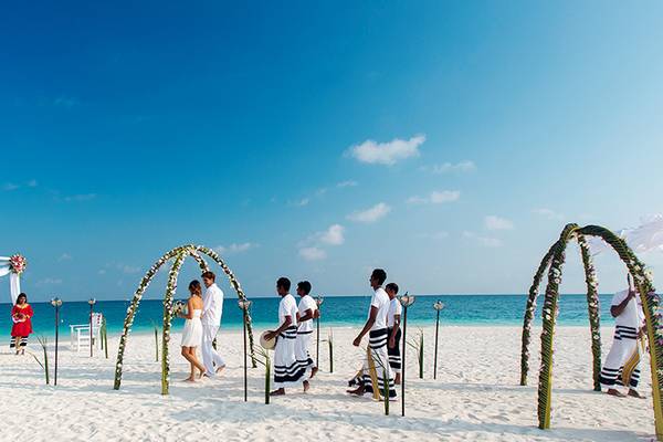 Hochzeitszeremonie am Strand im Velassaru Maldives mit Brautpaar und Gästen.