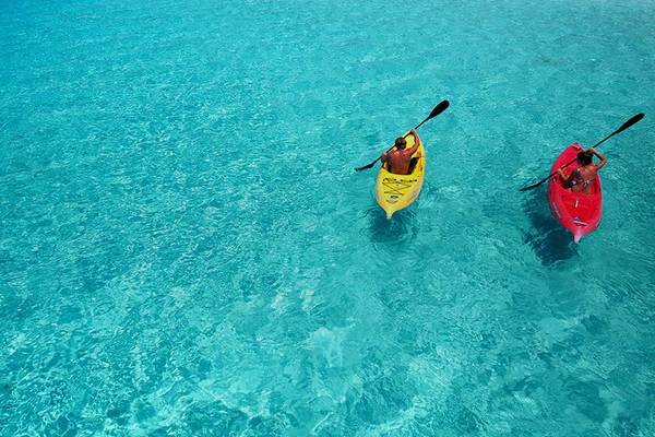 Zwei Kajakfahrer im kristallklaren Wasser von Velassaru Maldives.