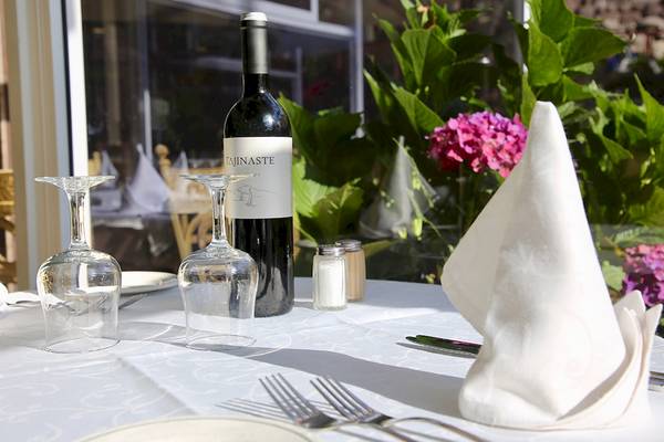 Ein Tisch im Puerto Palace Hotel mit Weinflasche, Gläsern, Besteck und Servietten.