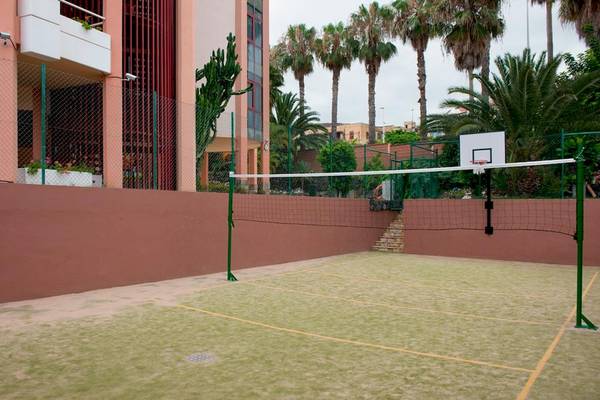 Ein Außenbereich vor dem Puerto Palace Hotel mit einem Basketballkorb und einem Volleyballnetz.