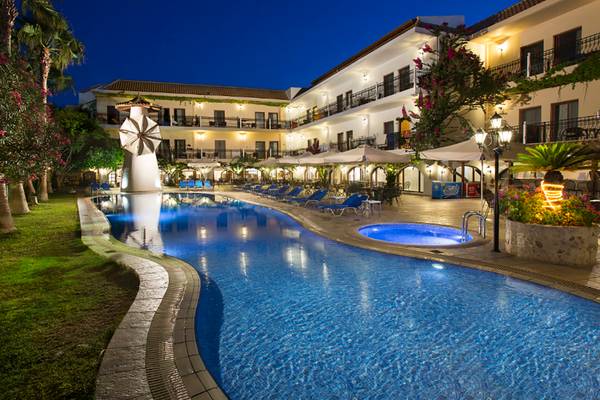 Nachtansicht des Almyrida Beach Hotels mit Swimmingpool und Liegestühlen