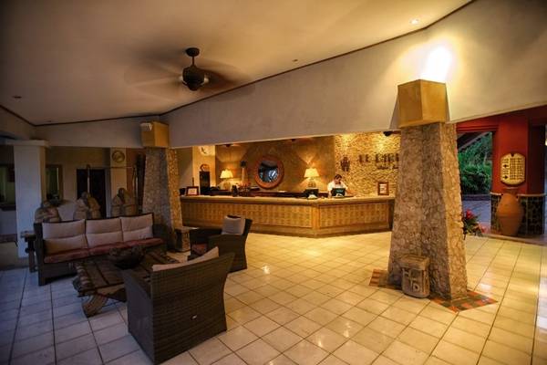 Empfangsbereich des Tamarindo Diria Beach Resorts mit Rezeptionstresen, Möbeln und Deckenventilator.