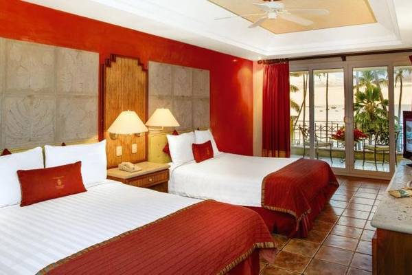 Doppelzimmer im Tamarindo Diria Beach Resort mit zwei Betten, rotem Dekor, Balkon und Meerblick.