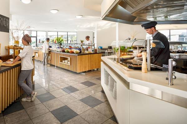 Ein Innenbereich des Remisens Hotel Albatros mit Mitarbeitern, die Speisen zubereiten.