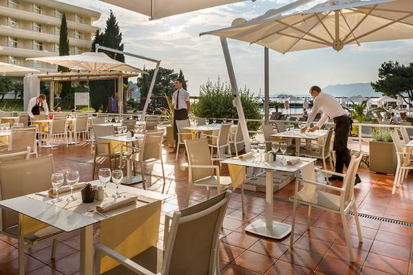 Außenterrasse des Remisens Hotel Albatros mit Gästen und Personal, servierend.