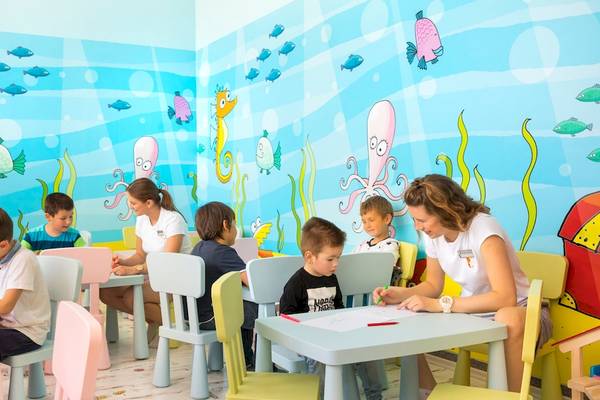 Kinder in einem Unterhaltungsraum des Remisens Hotel Albatros, der mit Meerestieren bemalten Wänden