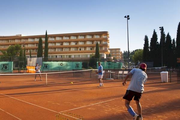 Tennisspieler spielen auf einem roten Tennisplatz vor dem Remisens Hotel Albatros.