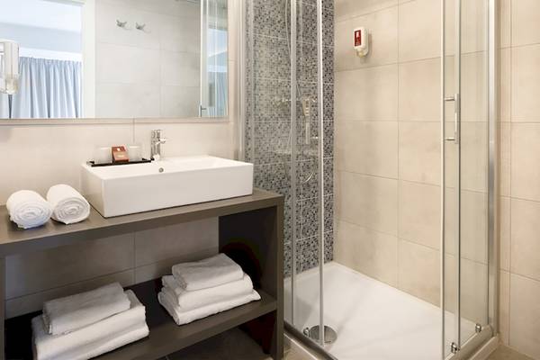 Badezimmer im Remisens Hotel Albatros mit Dusche, Waschbecken und Handtüchern