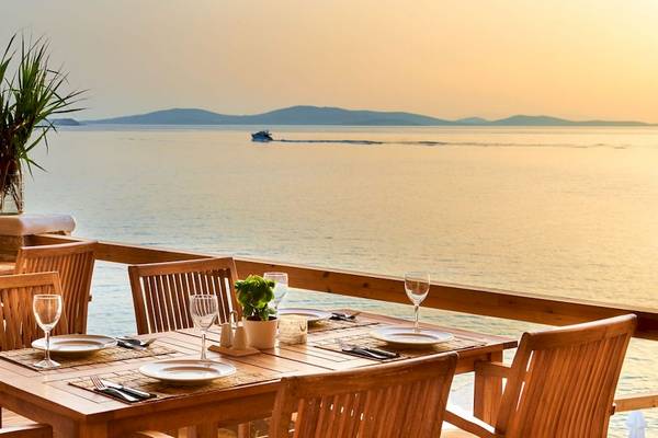 Terrasse des Saint John Hotel Villas & Spa mit Blick auf das Meer und Inseln.