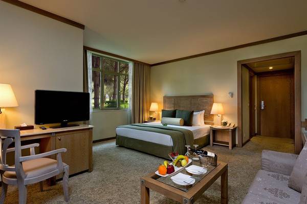 Hotelzimmer im Gloria Verde Resort mit Bett, Schreibtisch, Fernseher, Tisch und Couch