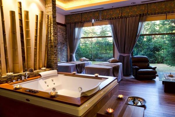 Wellnessbereich im Gloria Verde Resort mit Jacuzzi, Behandlungsliege und Blick ins Grüne