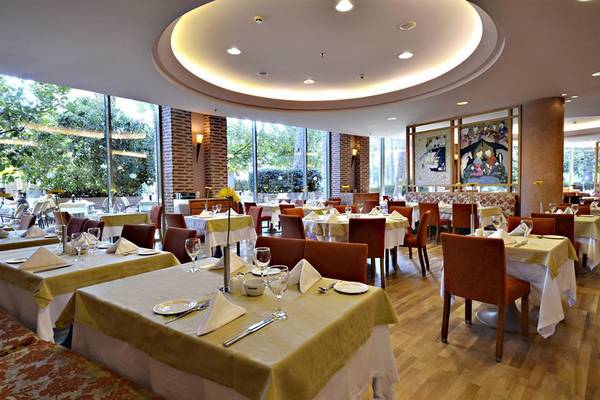 Restaurant des Gloria Verde Resorts mit runden Deckenbeleuchtung und großen Fenstern
