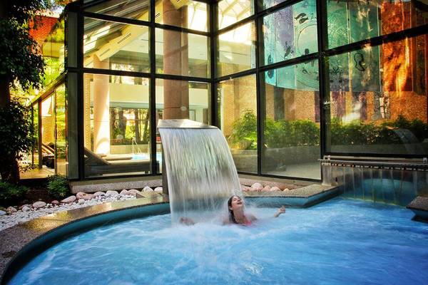 Frau genießt einen Wasserfall im Gloria Verde Resort Hotel