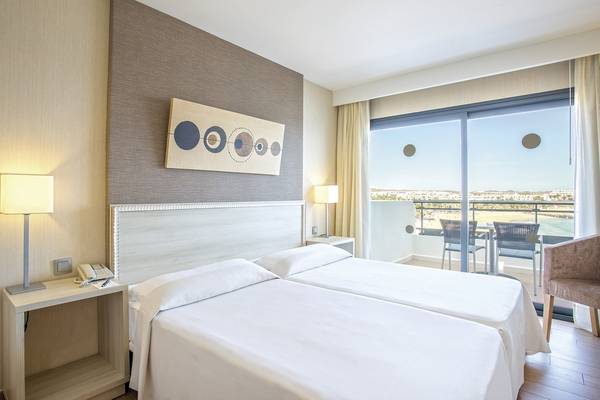 Doppelbettzimmer im Be Live Experience Lanzarote Beach Hotel mit Meerblick und Balkonmöbeln.