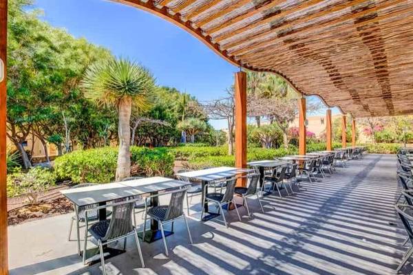 Terrasse des SBH Taro Beach Hotels mit Tischen und Stühlen unter einem Baldachin