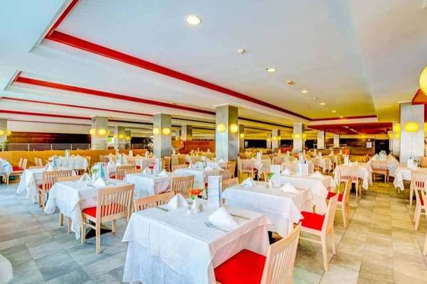 Restaurant im SBH Taro Beach Hotel mit vielen gedeckten Tischen und Stühlen.