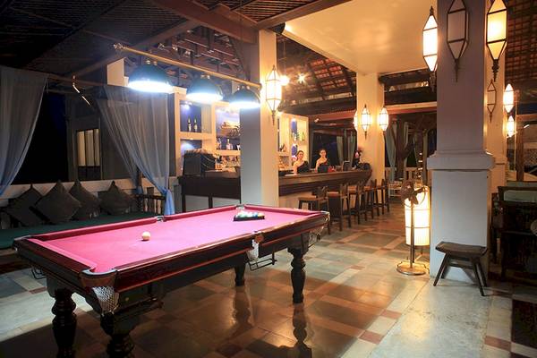 Ein roter Pooltisch im Barbereich des Khao Lak Laguna Resorts, mit zwei Frauen hinter der Bar.