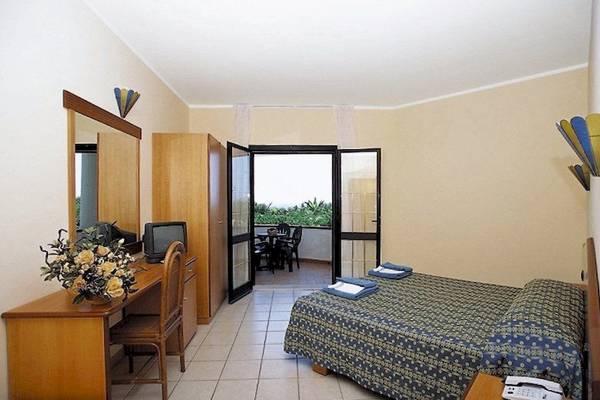 Hotelzimmer mit Balkon, Bett, Schreibtisch und Fernseher.