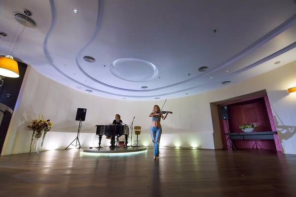 Eine Violinistin spielt in einem eleganten Saal im Olympic Palace Resort.