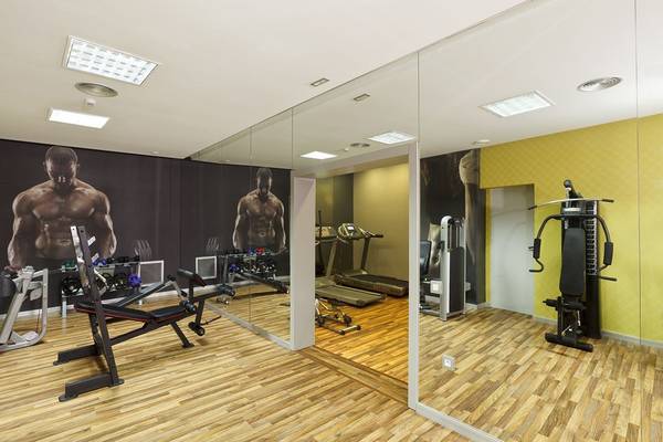 Fitnessstudio im Olympic Palace Resort mit Spiegelwänden und Trainingsgeräten.