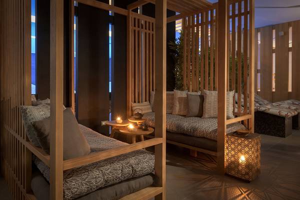 Wellnessbereich im Olympic Palace Resort mit Holzbetten und Kerzenbeleuchtung.