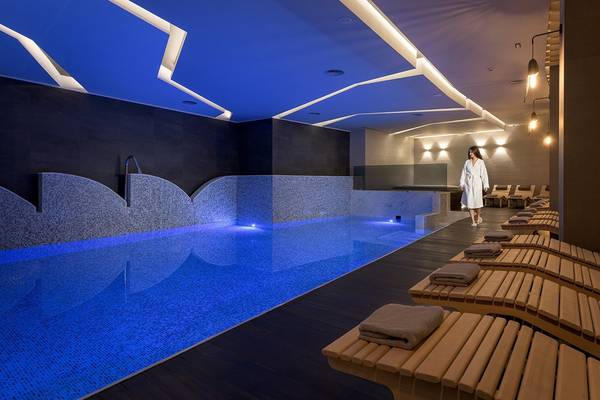 Innenpool des Olympic Palace Resort mit blauem Wasser und Loungeliegen