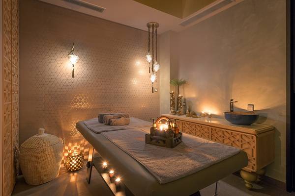 Spa-Behandlungsraum im Olympic Palace Resort mit Beleuchtung und Massageliege.