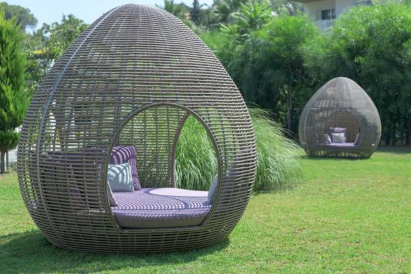 Zwei ovale Rattan-Loungesessel im Freien im Olympic Palace Resort.
