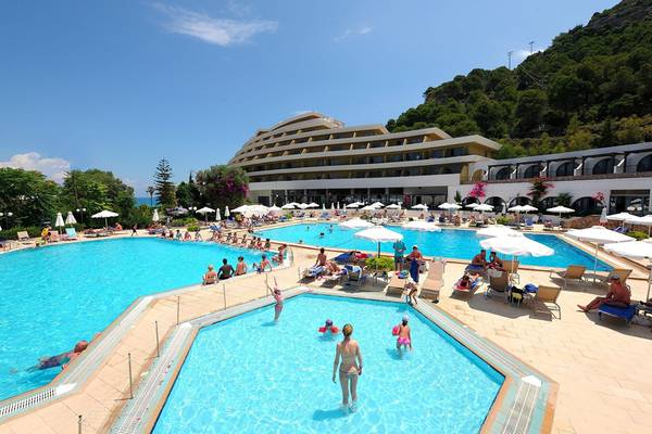 Außenpoolbereich des Olympic Palace Resorts mit Gästen und Sonnenschirmen.