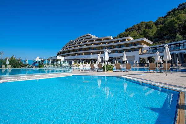 Außenpoolbereich des Olympic Palace Resorts mit Sonnenliegen und weißen Sonnenschirmen.