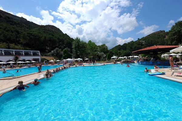 Ein großer Pool im Olympic Palace Resort mit vielen Gästen und Sonnenschirmen.