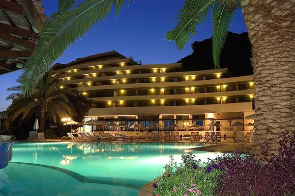 Das Olympic Palace Resort Hotel mit beleuchteter Poolanlage bei Nacht.