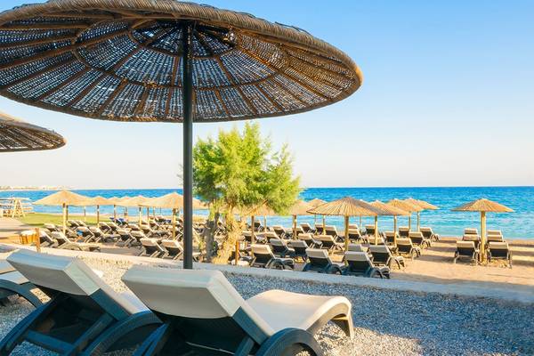Am Strand des Olympic Palace Resorts mit vielen Liegestühlen und Sonnenschirmen.