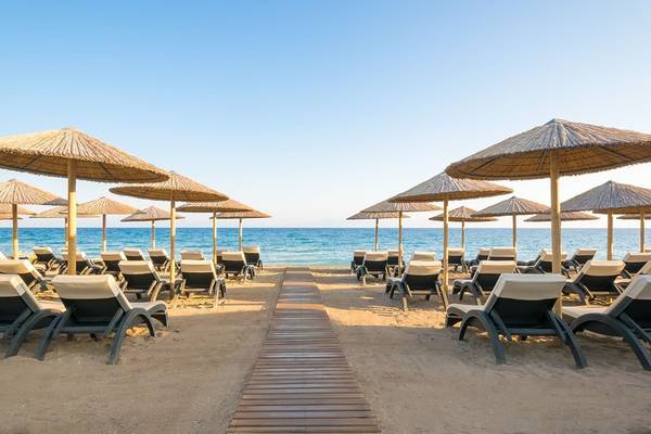 Strandszene mit vielen Liegestühlen und Sonnenschirmen am Olympic Palace Resort