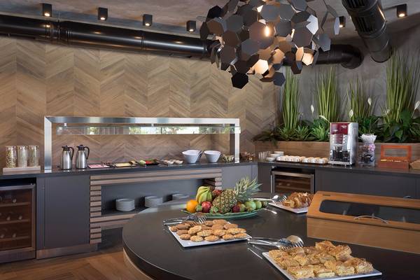Frühstücksbuffet im Olympic Palace Resort mit Obst, Gebäck und Kaffeemaschine.