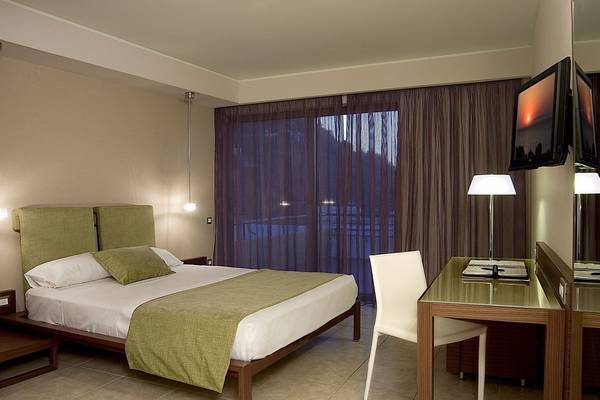 Hotelzimmer im Olympic Palace Resort mit Bett, Schreibtisch und Fernseher.