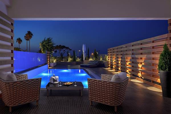 Loungebereich mit zwei Stühlen und einem Tisch im Freien neben dem Pool des Olympic Palace Resorts.