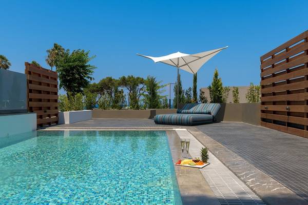 Pool-Terrasse im Olympic Palace Resort mit Sonnenschirm und Obstplatte