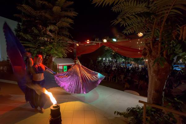 Feuershow im Freien beim Olympic Palace Resort bei Nacht mit Zuschauern und rotem Vorhang.