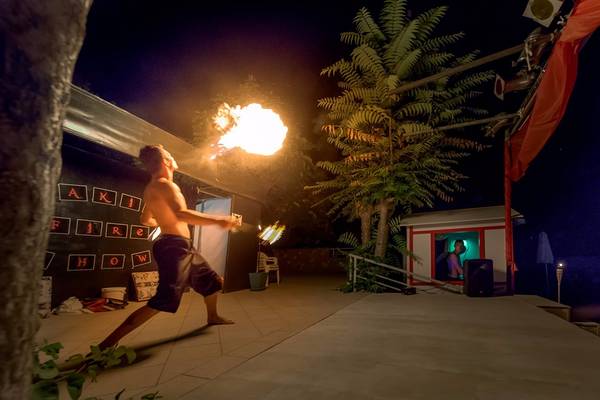 Feuershow im Freien am Olympic Palace Resort mit einem Mann, der Feuer spuckt.